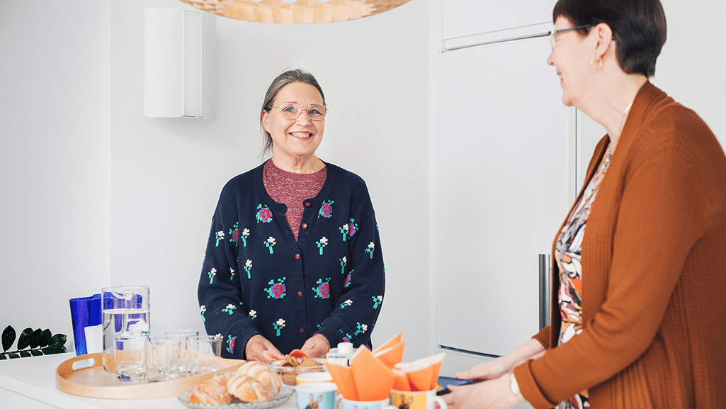 Kaksi hymyilevää henkilöä kahvitarjoilujen äärellä, Pirsyn vapaaehtoisia